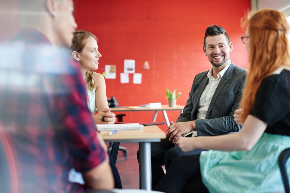 Unposed group of creative business people in an open concept office brainstorming their next project.