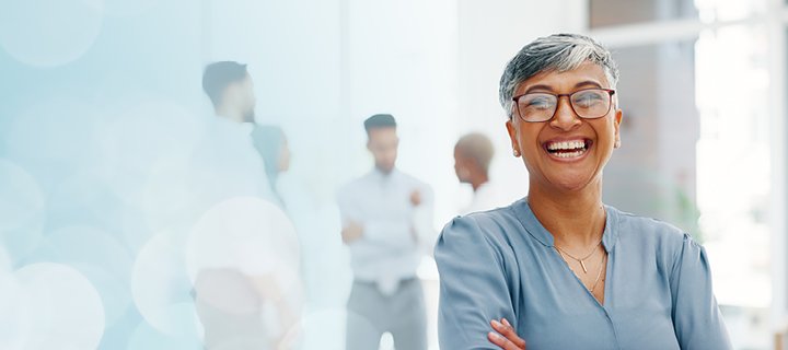 A person in an office setting, smiling and looking happy